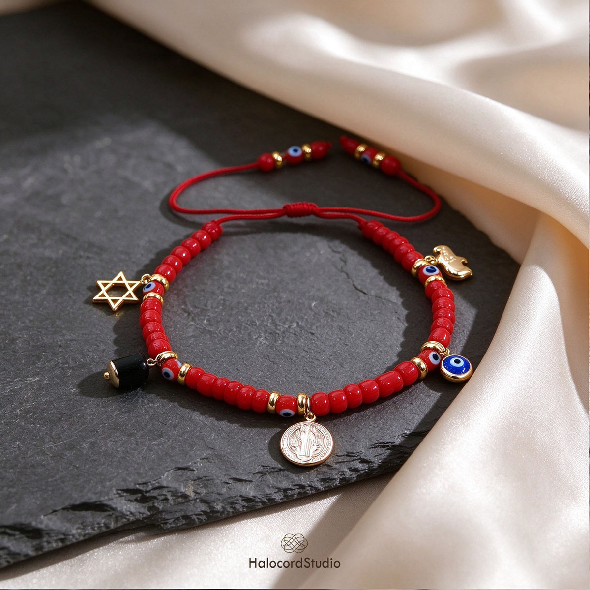 Evil eye red seed bead charm bracelet with lucky elephant and Star of David on dark slate