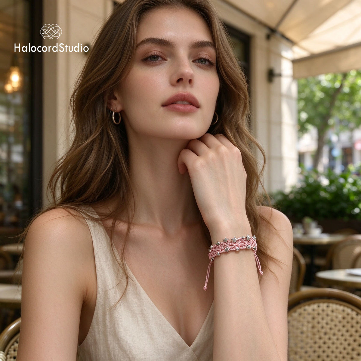 Lifestyle model wearing the pink handmade star charm woven bracelet with an elegant casual summer outfit