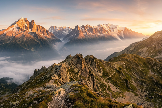 Majestic alpine summit trail at sunrise overlooking misty mountain horizon bathed in golden light