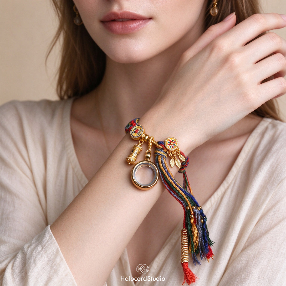 Handwoven Tibetan multi-color braided bracelet worn on woman's wrist showing adjustable sliding knot and tassel charms